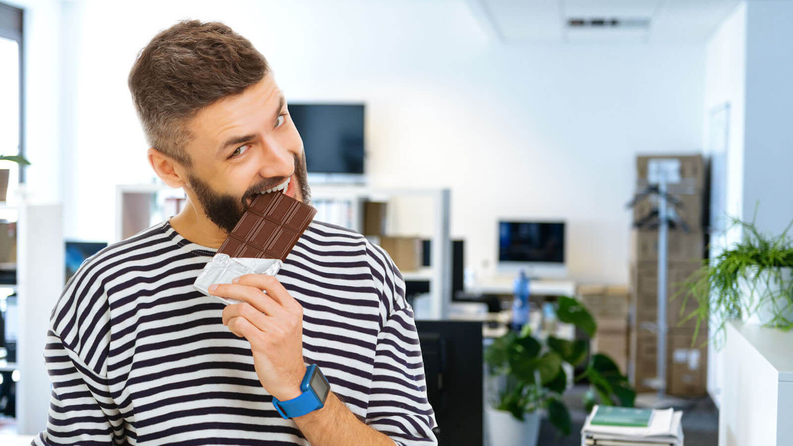 Mann beißt in Büro in Schokolade